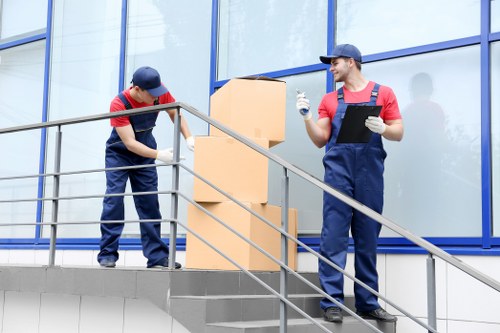 Professional movers handling an upright piano in Finchley